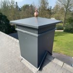 Koperen bol met grote piek op schoorsteenkap van een huis als versiering