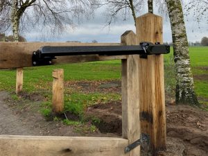 Zwarte Fadini HINDI lineaire poortopener als poortautomatisering bij een houten toegangspoort